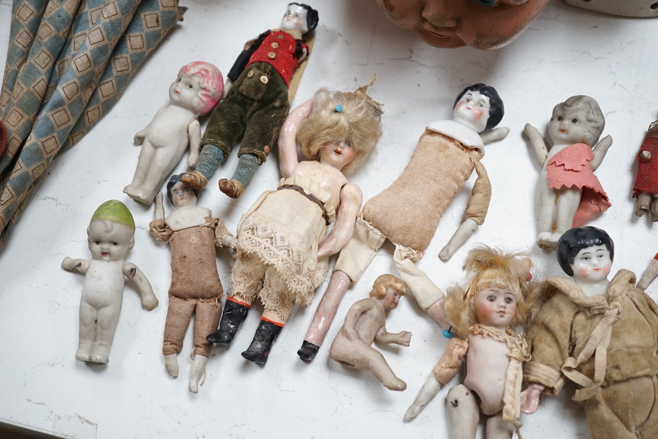 Two Kammer and Reinhardt bisque headed dolls, a wax over composition doll, various other bisque headed dolls and a few single heads and a collection of miniature dolls